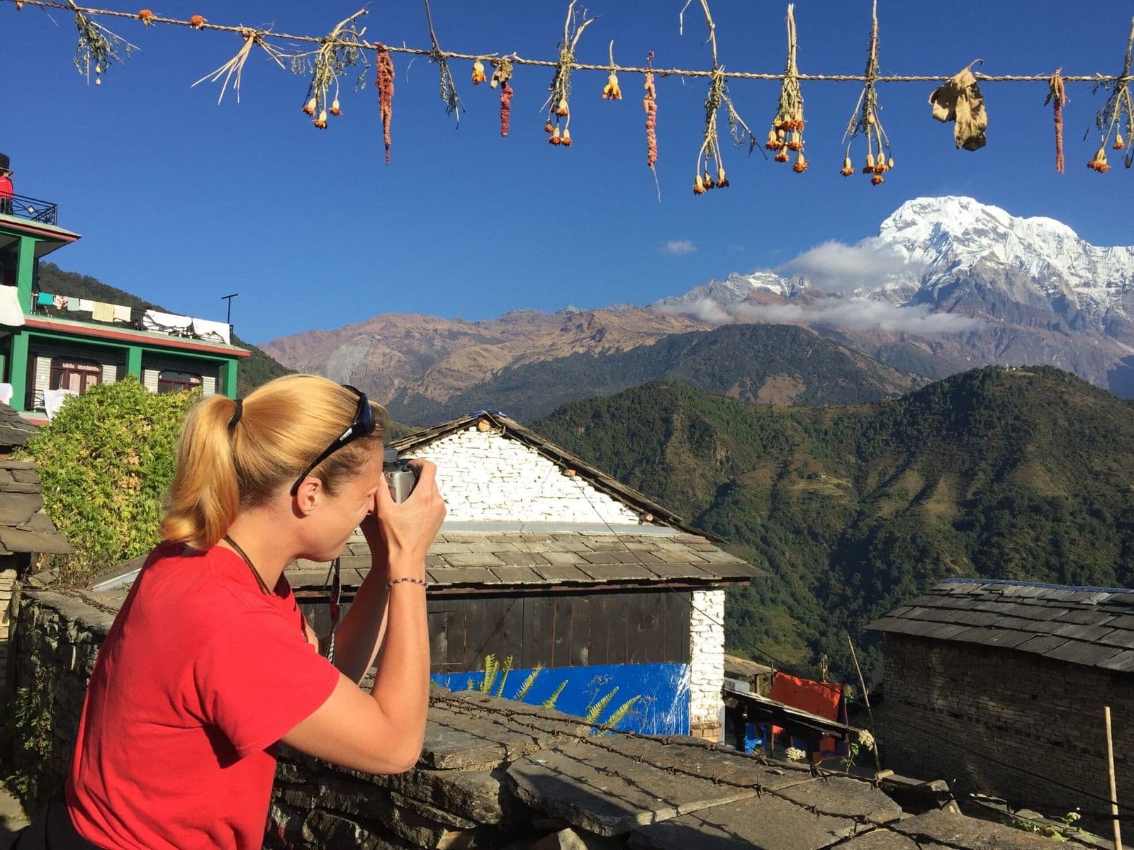 Trekker photographing the Annapurnas from a mountain lodge