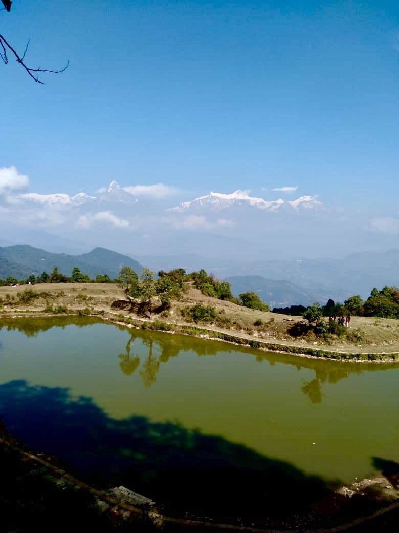 Small lake reflecting the sky on a forest ridge