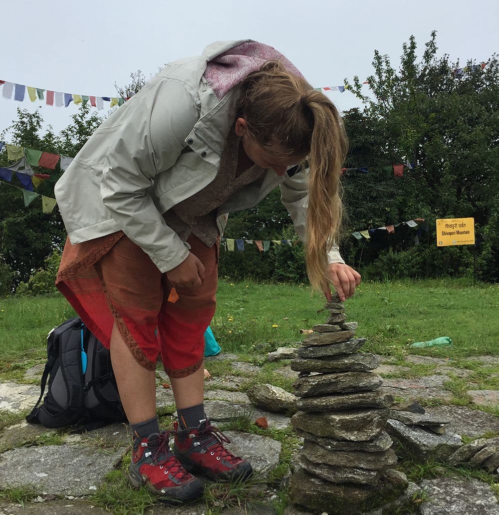 Trekker building a stone cairn