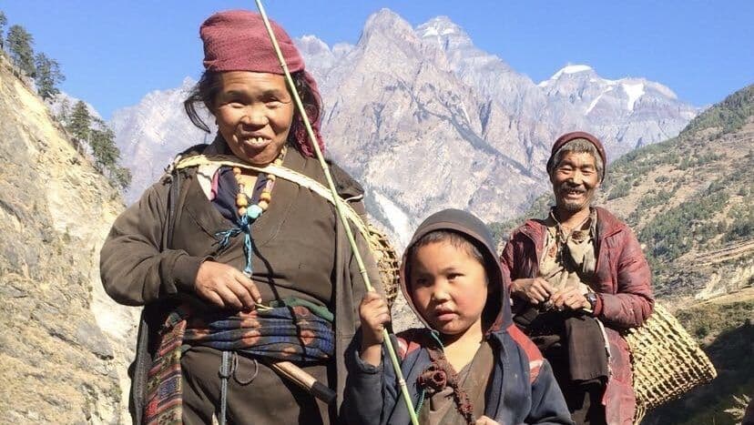 Elderly villagers and a child on the trail