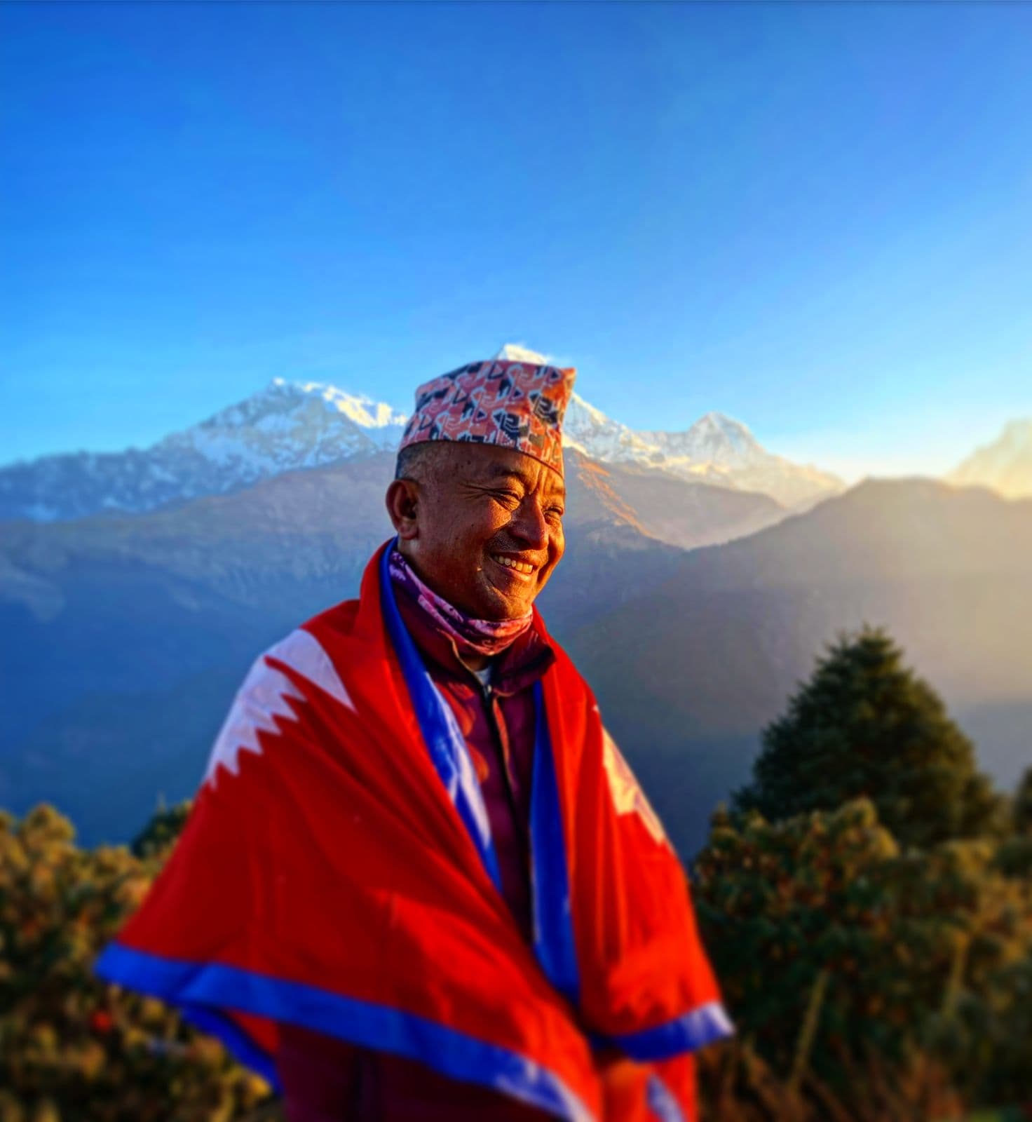 Smiling Nepali elder in traditional dress and dhaka topi