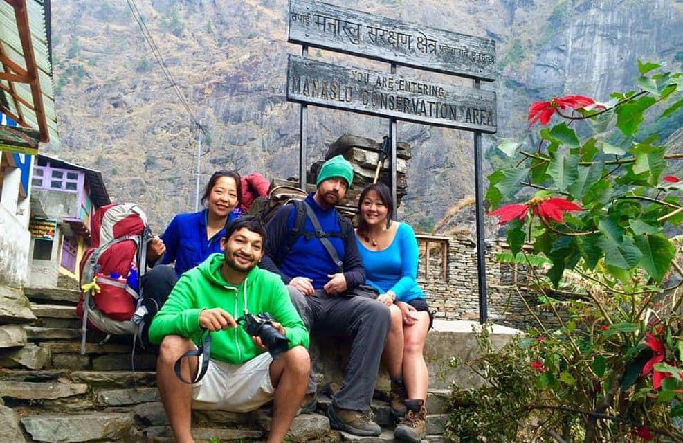 Trekking group resting at a trail sign