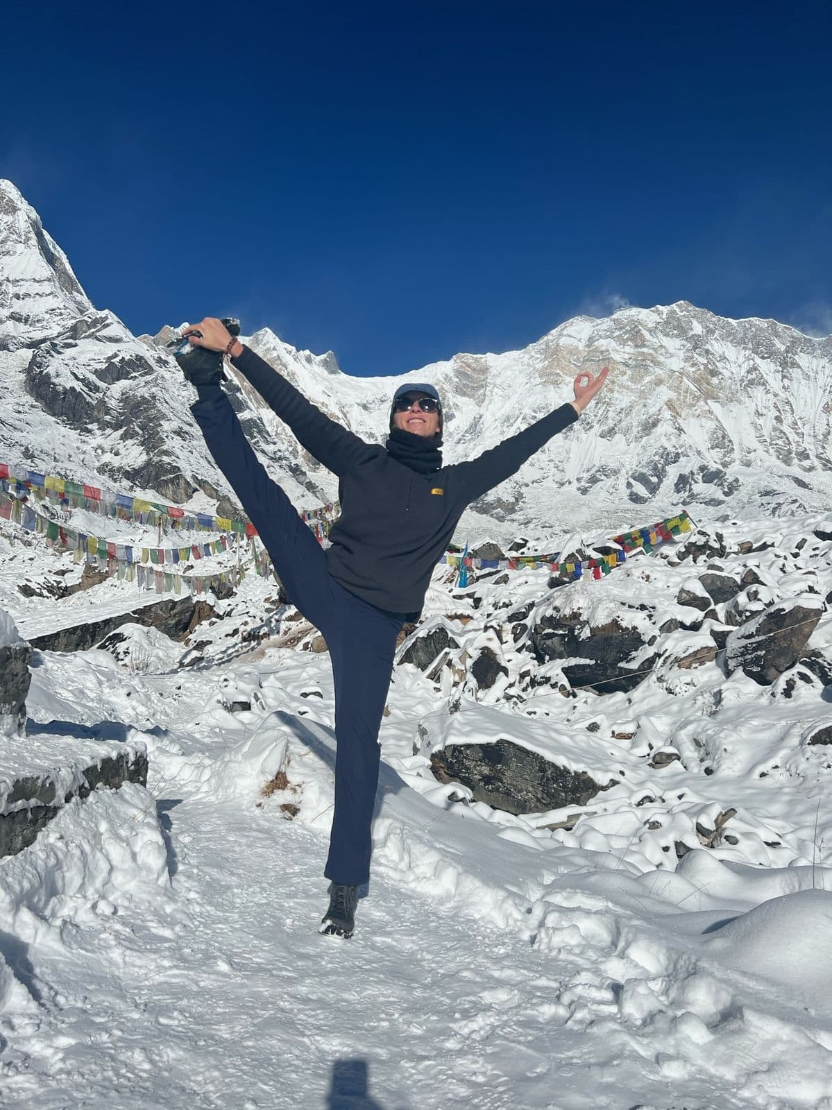 Trekker doing a yoga pose in the snow