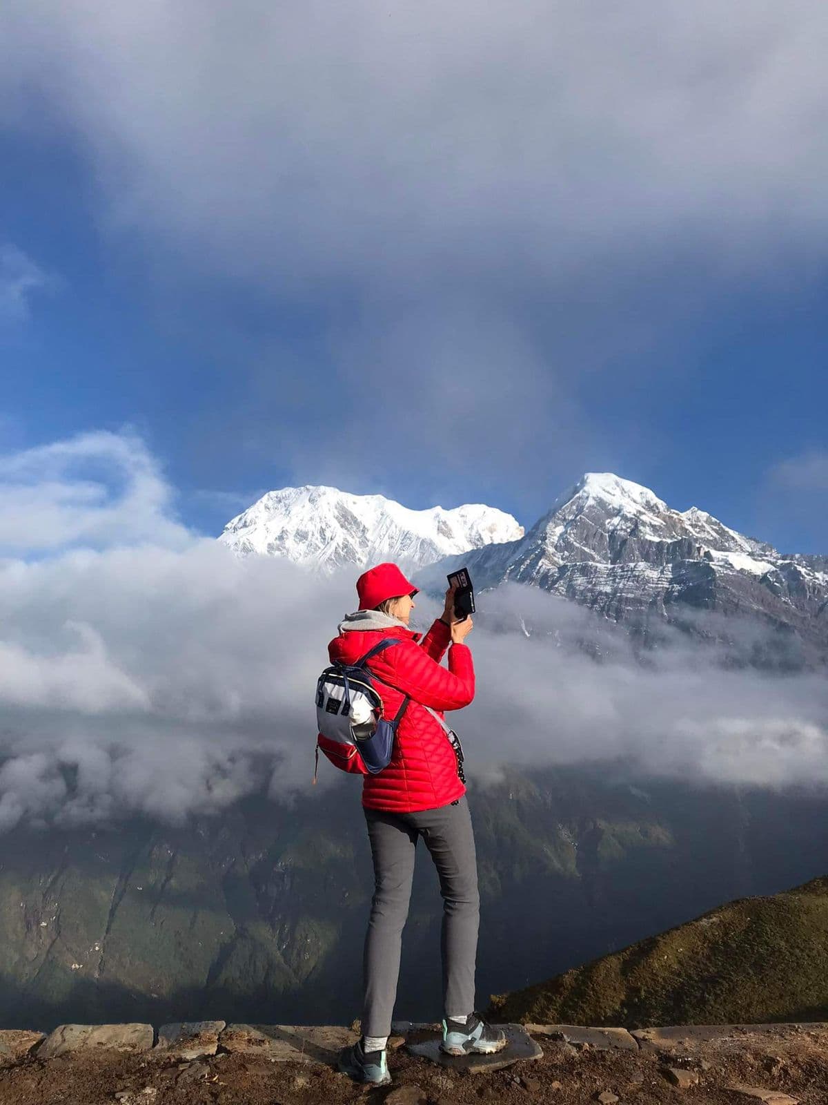 Trekker in a red jacket facing the Annapurnas