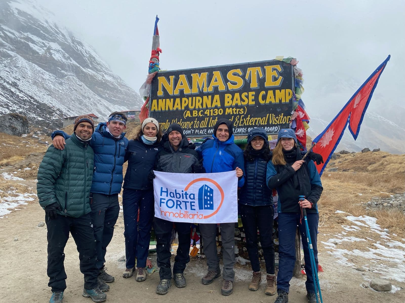 Group with banner at the Annapurna Base Camp sign