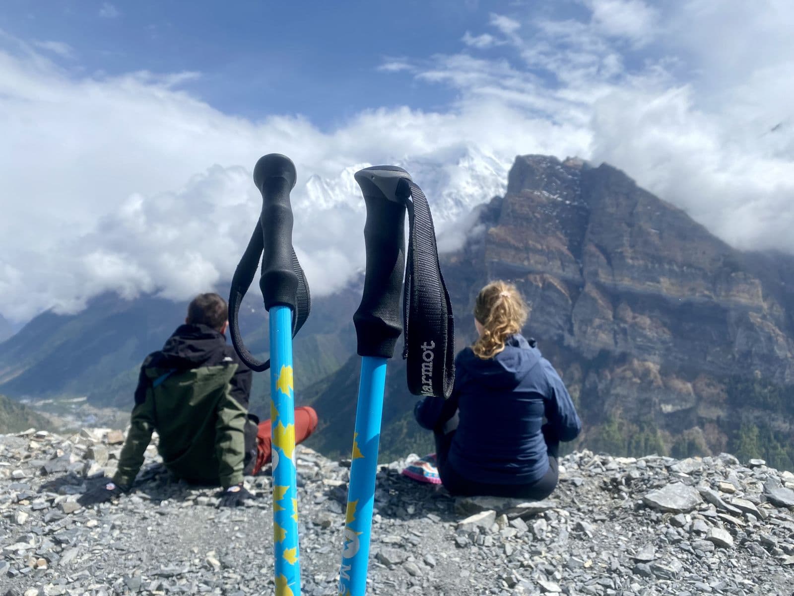 Two trekkers resting beside their trekking poles