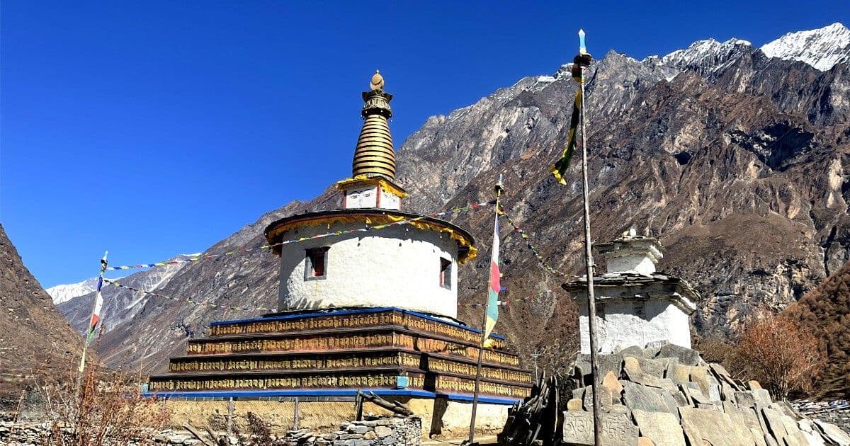 Large stupa and prayer flag pole in a mountain village