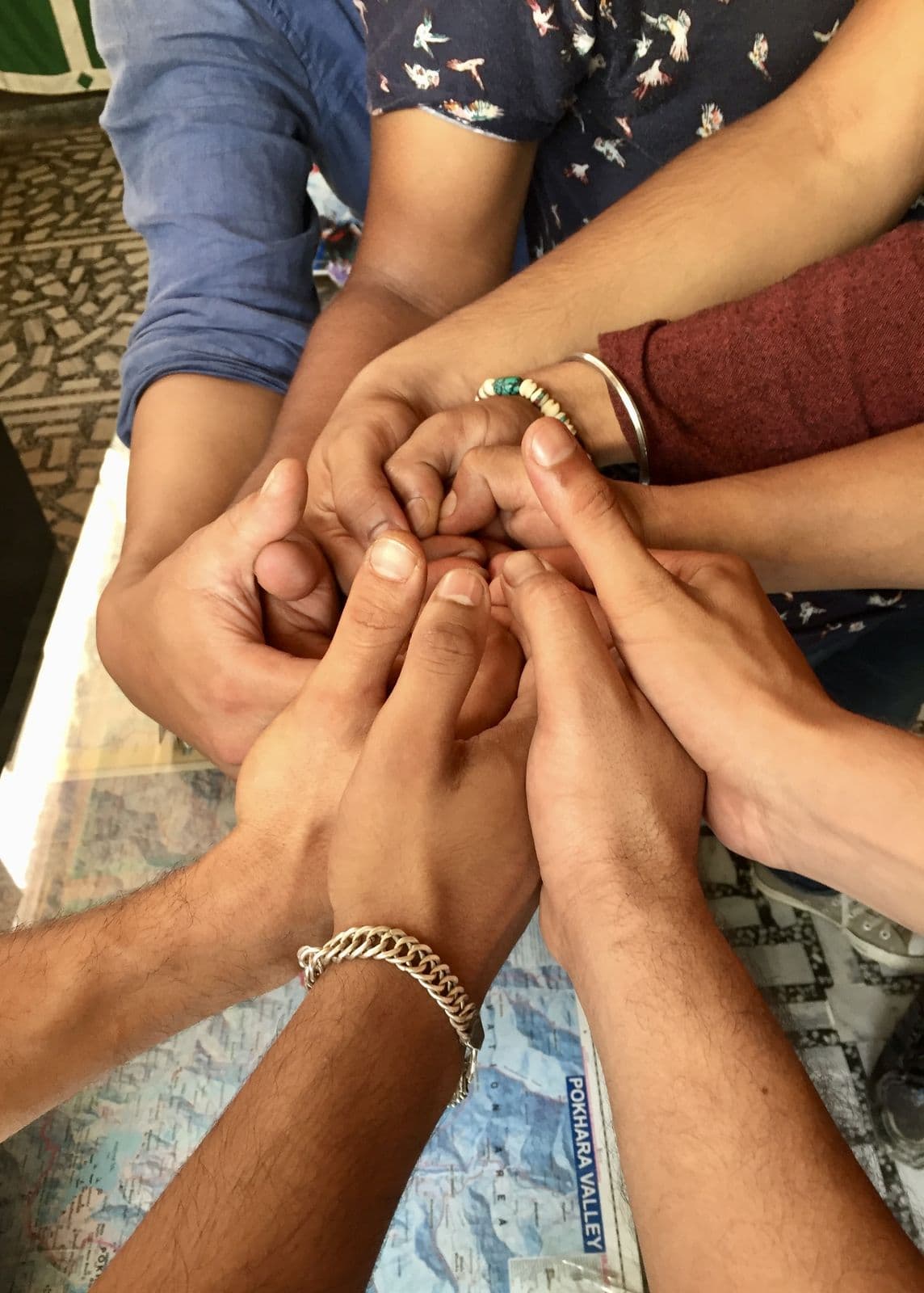 Hands joined together in a team huddle