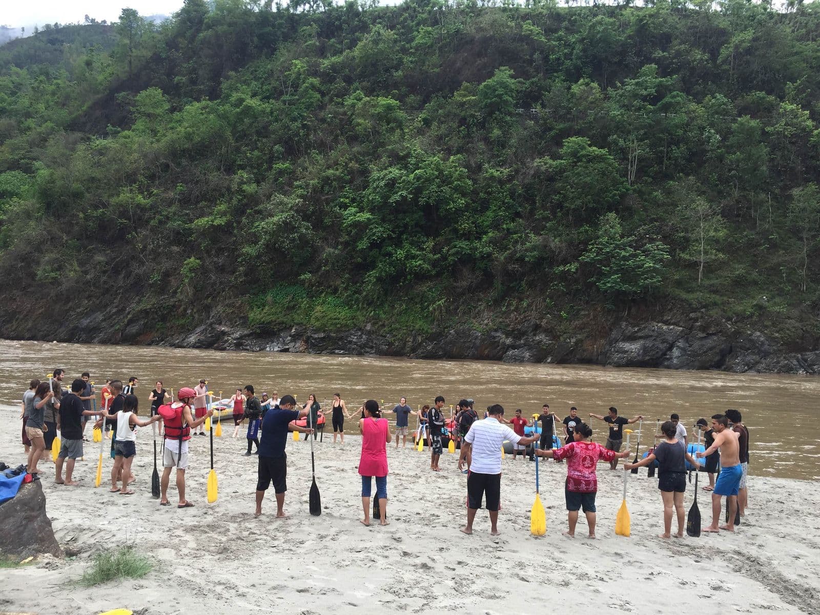 Rafting group gathered on a sandy riverbank